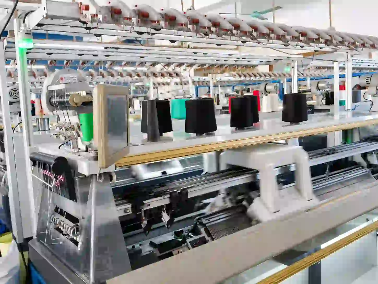 Computerized flat knitting machines running in a knitwear production workshop